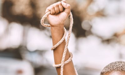 Hand, rope and fist protest slavery for freedom and human rights against an urban background. Activist, activism and rebellion against racism and change for civil, law and government rights (Photo by Jacob Wackerhausen)