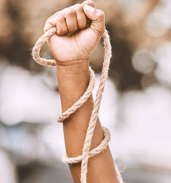 Hand, rope and fist protest slavery for freedom and human rights against an urban background. Activist, activism and rebellion against racism and change for civil, law and government rights (Photo by Jacob Wackerhausen)