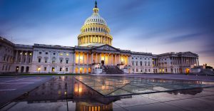 Capitol building in Washington DC illuminated against a stormy sky