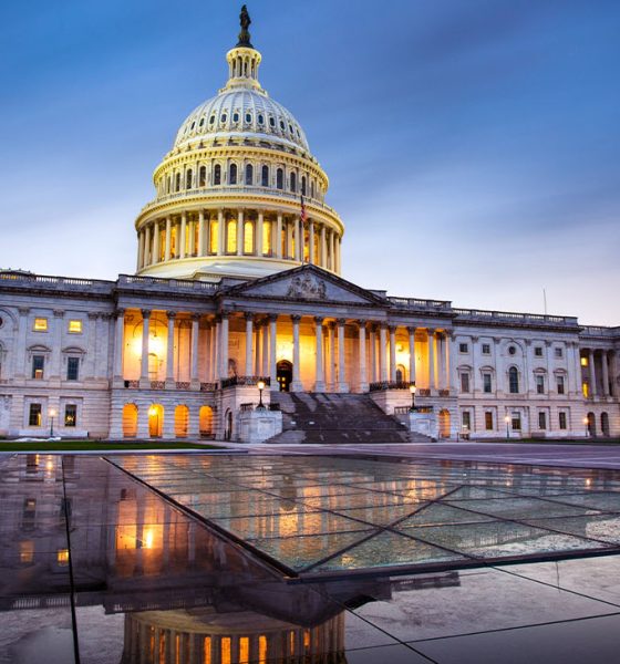 Capitol building in Washington DC illuminated against a stormy sky