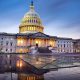 Capitol building in Washington DC illuminated against a stormy sky