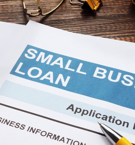 Small business loan application on the wooden surface and documents.
