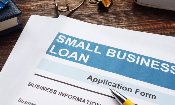 Small business loan application on the wooden surface and documents.