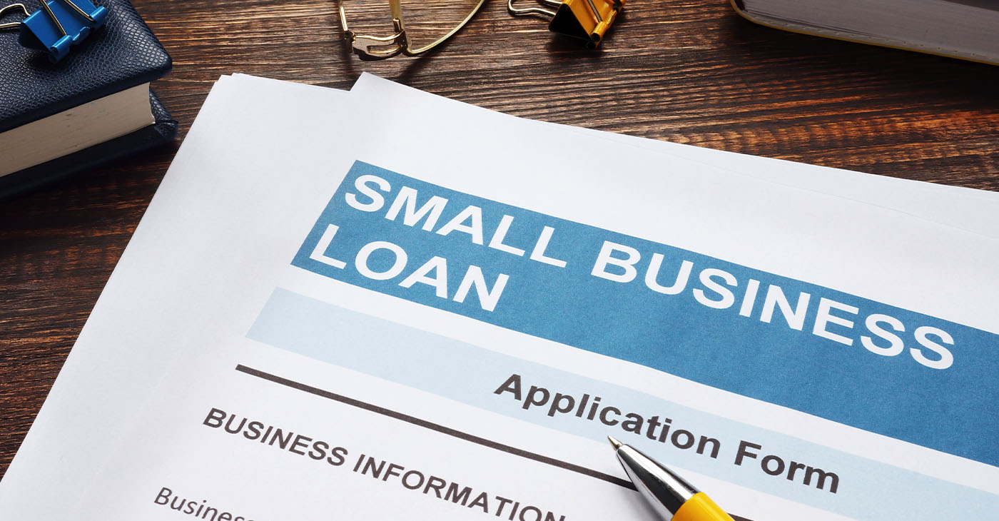 Small business loan application on the wooden surface and documents.
