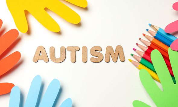 Multicolored paper hands with pencils on white background. World autism day concept (Photo by Liliia Bila)