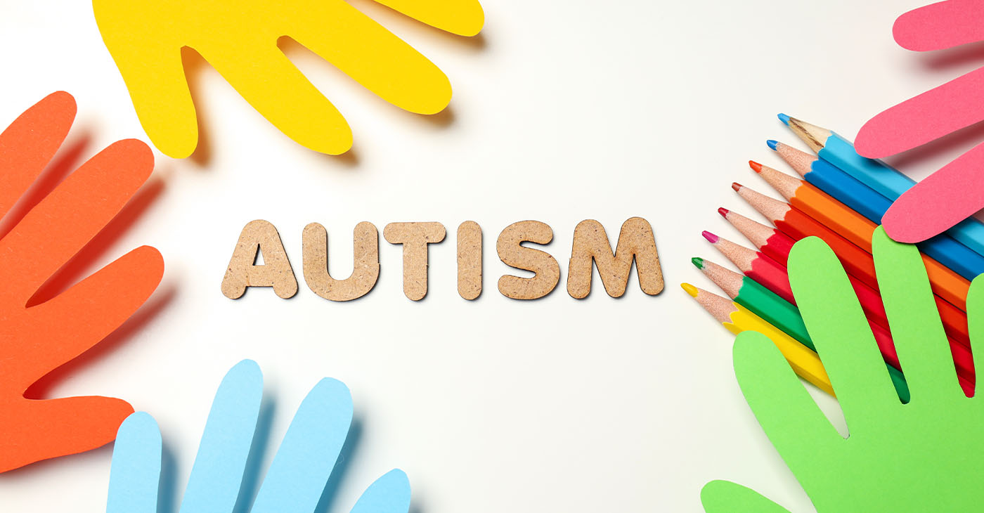 Multicolored paper hands with pencils on white background. World autism day concept (Photo by Liliia Bila)