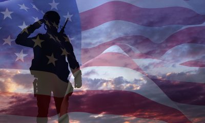 Silhouette of a soldier with USA flag against the sunset