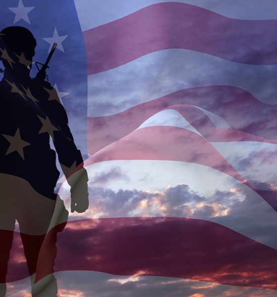 Silhouette of a soldier with USA flag against the sunset