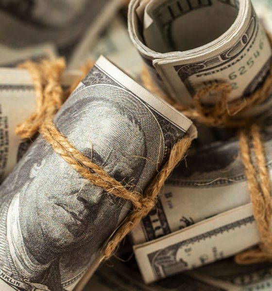 A detailed close-up of tightly rolled bundles of US dollar banknotes, suggesting accumulated wealth or savings. However, in the context of inflation, this image subtly conveys the idea that even significant amounts of money can lose their real value over time. It represents the quiet erosion of purchasing power, making it a compelling visual for discussions on long-term financial planning, investment strategies, the impact of rising prices on accumulated capital, and the challenge of preserving wealth in an inflationary economy.