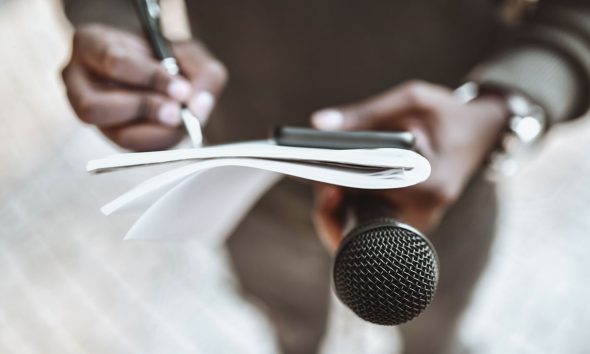 Male Journalist Preparing Questions For Press Conference (Photo by Aleksandar Georgie)
