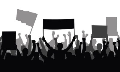 Silhouette of a crowd of people with hands in the air - show spectators, sport fans, protest, demonstration, music festival, people cheering vector illustration