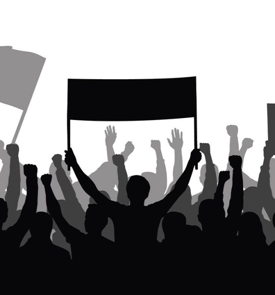 Silhouette of a crowd of people with hands in the air - show spectators, sport fans, protest, demonstration, music festival, people cheering vector illustration