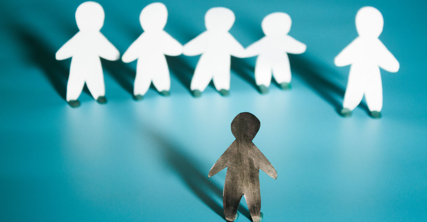 Racism concept image. White paper person agains black paper person (Photo by Liia Galimzianova)