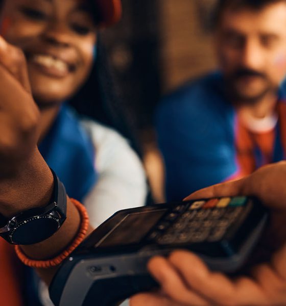 Close up of a woman paying contactless with smart watch during sports championship in a bar. (Photo by Drazen Zigic)