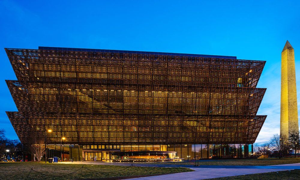 Washington D.C., USA - February 10, 2023: The National Museum of African American History and Culture at night with the Washington Monument in downtown Washington DC.