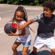 Brother and sister playing basketball and having fun outdoors.