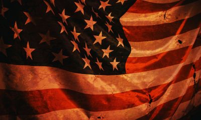 Closeup of grunged aged American flag over dark background