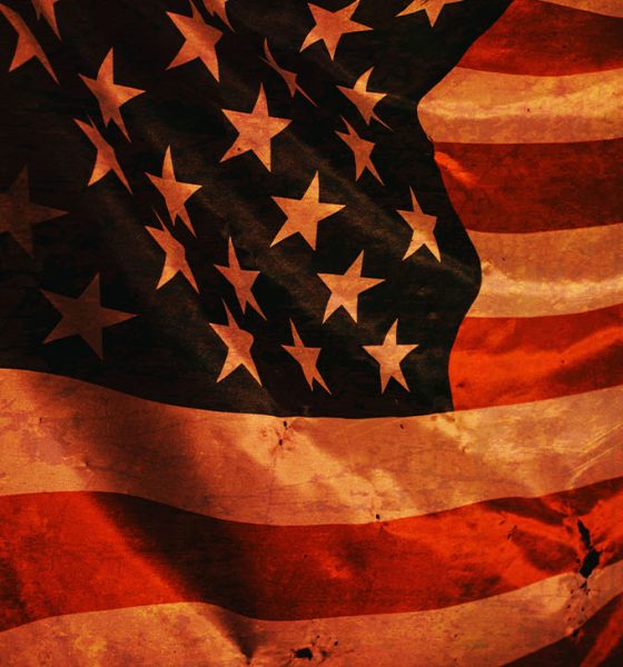 Closeup of grunged aged American flag over dark background
