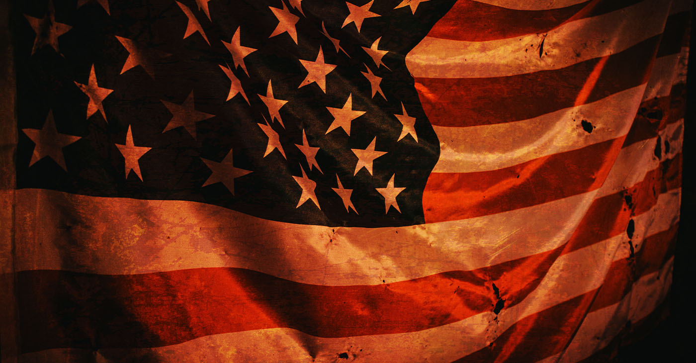 Closeup of grunged aged American flag over dark background