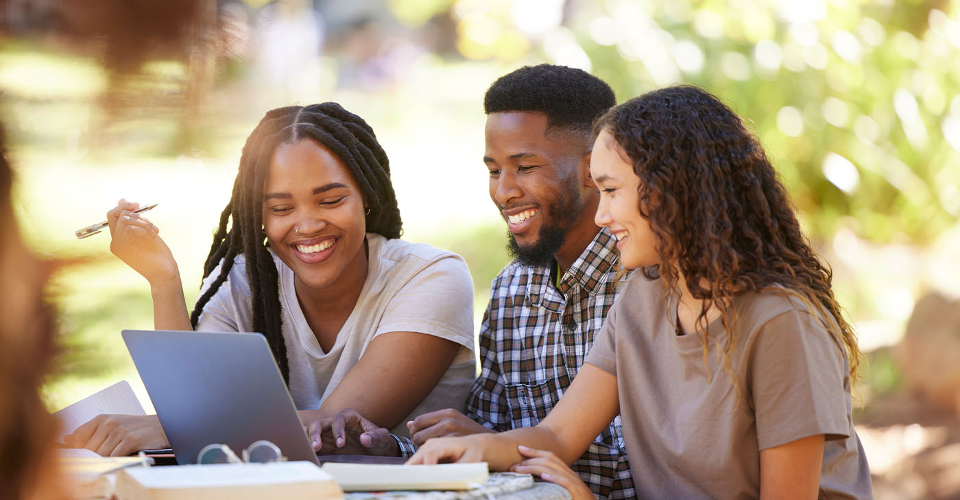 Students, friends and group studying with laptop at park outdoors. Education scholarship, learning teamwork and happy people, black man and women with computer for research at university or college.