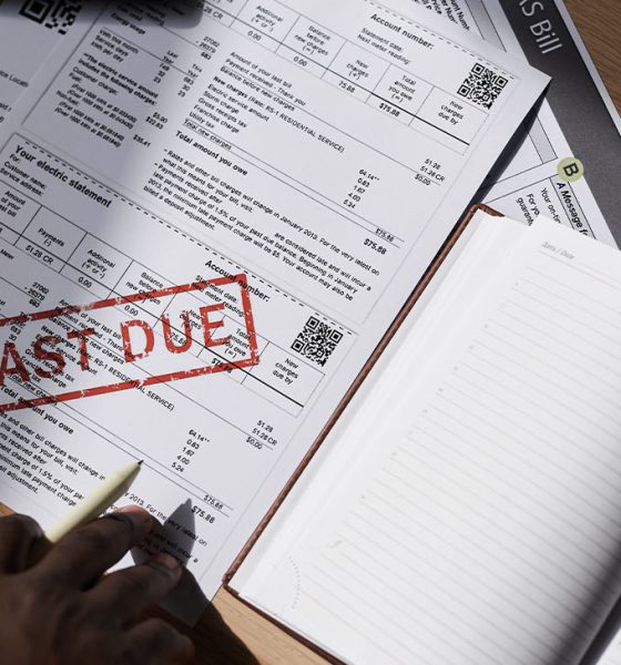 Top view closeup of unrecognizable man doing taxes at home with past due bill on table, copy space
