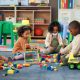 Kids, students and play with blocks in classroom for learning, problem solving and creative activity. Children, toys and floor for education game, puzzle solution and motor growth in kindergarten 