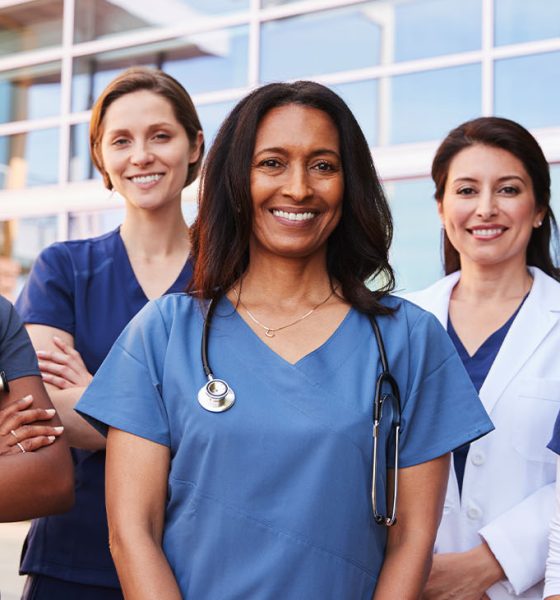 Female healthcare colleagues standing outside hospital