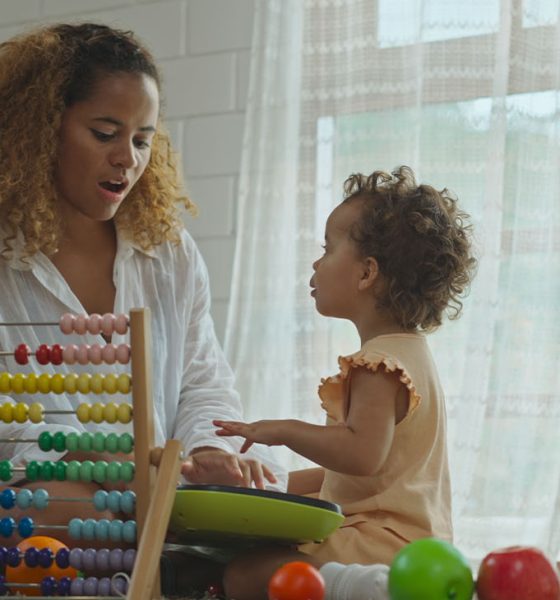 Mother and daughter are doing play a toy and having fun in living room.