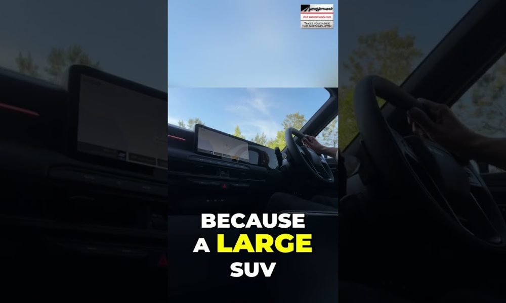 Interior of a car cabin with a large touchscreen/dashboard visible and bold text overlay: 'BECAUSE A LARGE SUV' in white and yellow.