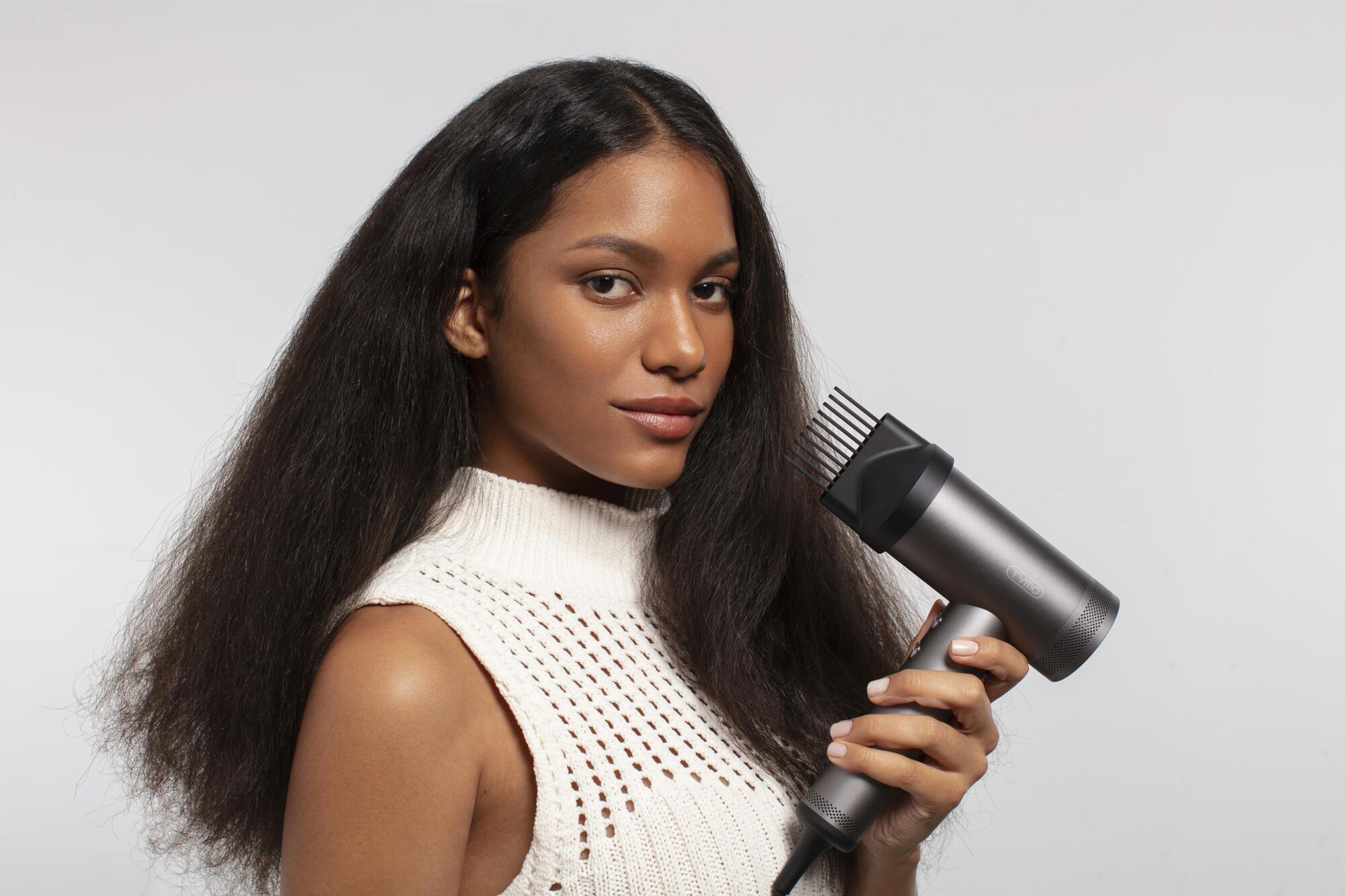 Woman holding blow dryer.