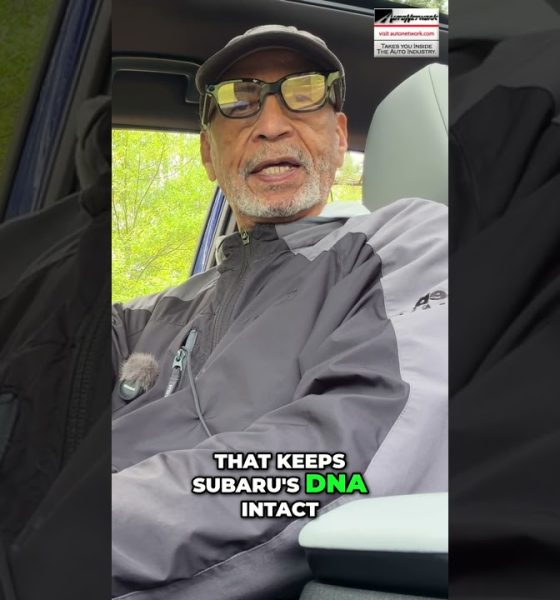 Man wearing a cap and glasses sits in a car, speaking to the camera; bold caption reads, 'That keeps Subaru's DNA intact' with 'DNA' highlighted in green.