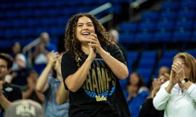 UCLA women's basketball team celebrating their national championship win, hoisting the trophy