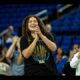 UCLA women's basketball team celebrating their national championship win, hoisting the trophy