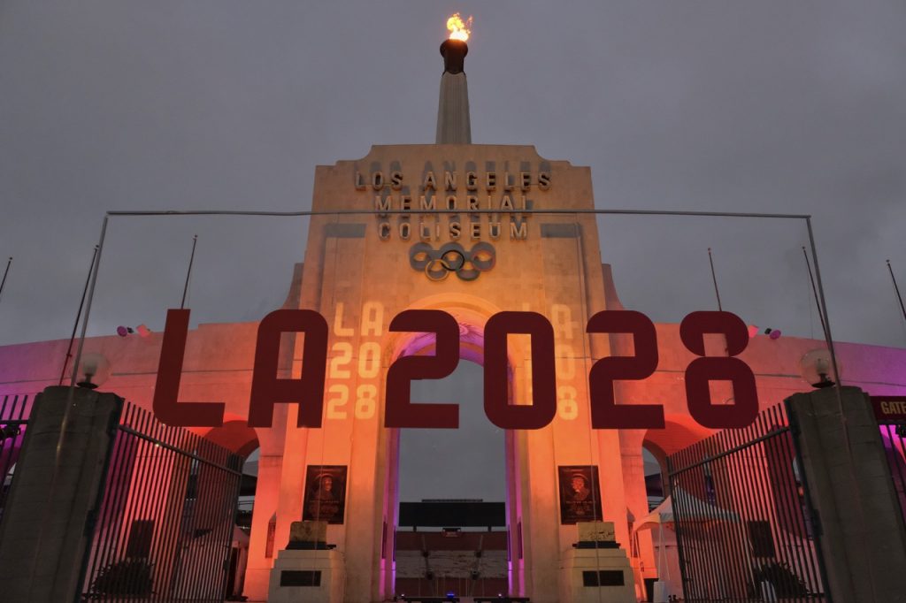 An LA2028 sign in front of a blazing Olympic cauldron at the Los Angeles Memorial Coliseum on Wednesday, Sept. 13, 2017. The cauldron was lit early Wednesday morning at the stadium that was the site of the 1932 and 1984 Olympics. (AP Photo/Richard Vogel)