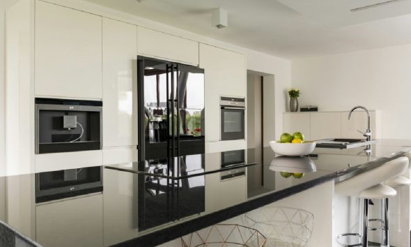 A modern kitchen featuring natural stone countertops and hardwood flooring.