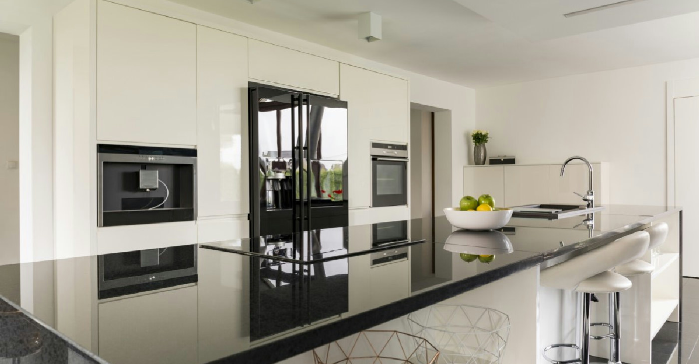 A modern kitchen featuring natural stone countertops and hardwood flooring.
