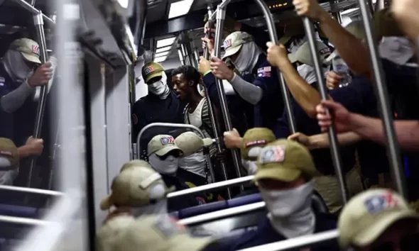 WASHINGTON, DC – JULY 04: A passenger (C) looks on as members of the white supremacist group Patriot Front ride the Washington Metro on July 04, 2026 in Washington, DC. Numerous events, activities, and fireworks are planned in celebration of America’s 250th Anniversary. (Photo by Finn Gomez/Getty Images)