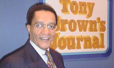 Tony Brown poses in front of the Tony Brown's Journal logo. Brown, who died June 17 at age 93, transformed Black public affairs television and influenced generations of journalists through his groundbreaking broadcast career.