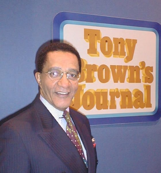 Tony Brown poses in front of the Tony Brown's Journal logo. Brown, who died June 17 at age 93, transformed Black public affairs television and influenced generations of journalists through his groundbreaking broadcast career.