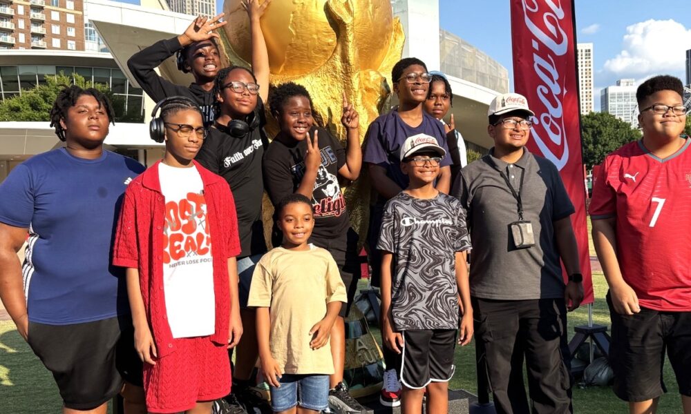 Tour participants stand in front of the Coca-Cola building in Atlanta, Ga