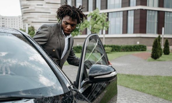 Man entering car with open car door.