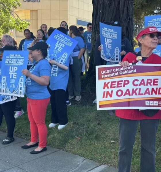 Staff and family members of patients at UCSF Benioff Children's Hospital Oakland in Oakland, Calif., hold signs during a rally on Thursday, July 9, 2026. Rally participants protested the relocation of specialized care clinics to the hospital's San Francisco campus. Photo by Kayla Chan/Bay City News.