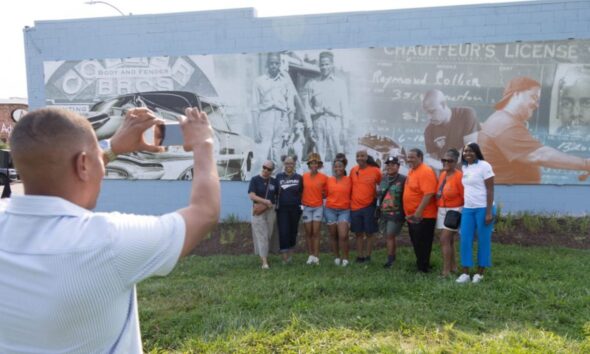 Larry Smith takes a photo during the Common Ground Community Car Show & Block Party celebrating 80 years of Collier Brothers Auto Body and the unveiling of a mural honoring the historic Black owned St. Louis business at 4561 Delmar Blvd. Lawrence Bryant | St. Louis American