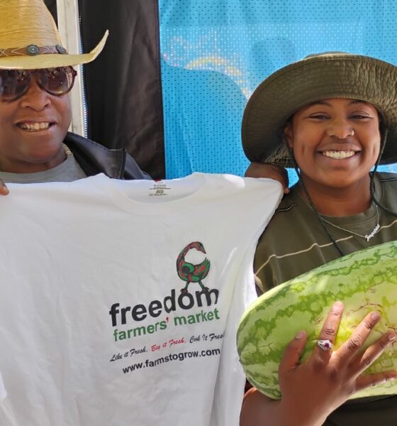 Elaine Smith, executive director of Farms to Grow, Inc., holds T-shirt for Ki’Ara LaFitte, winner of the Freedom Farmers’ Market Watermelon-Eating Contest at the season opening on July 11. Courtesy photo.