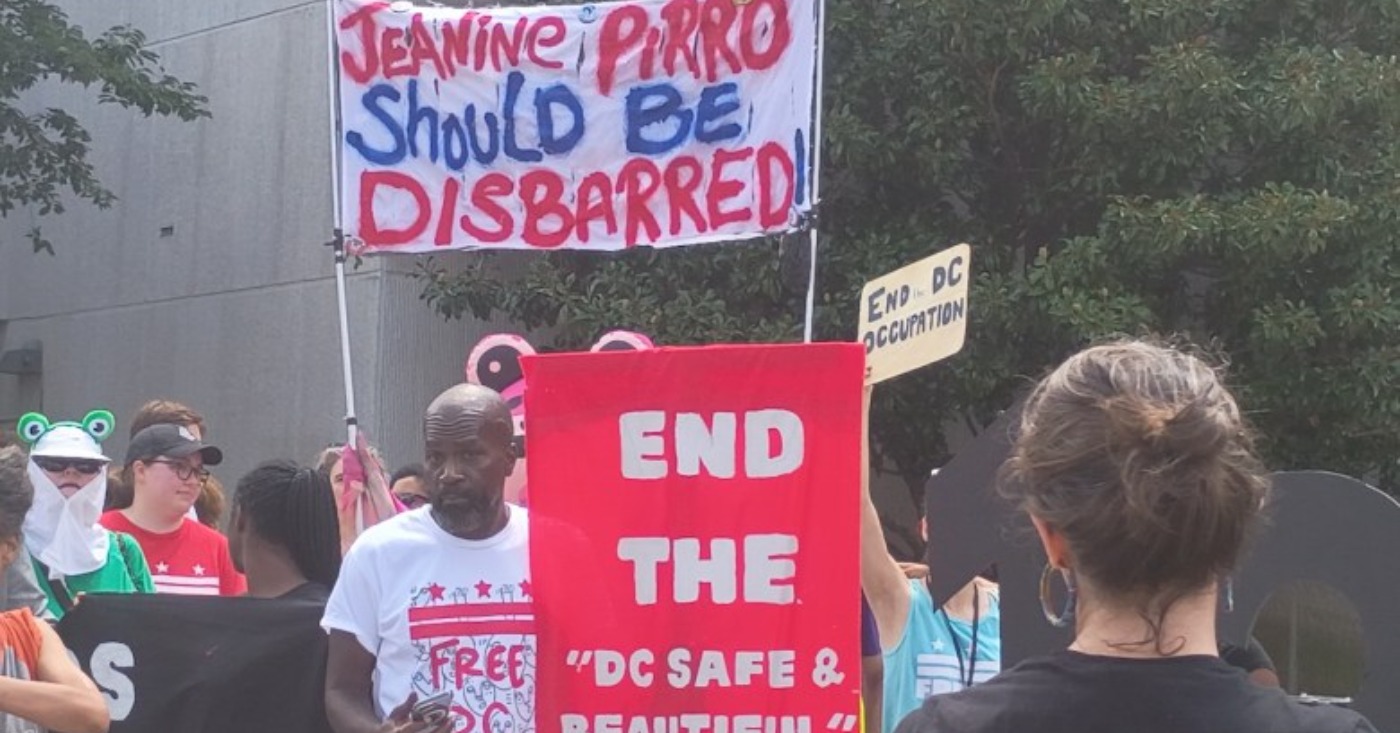 Jerome Hinkle counts among those who stood outside of D.C. Superior Court with signs in hand against U.S. Attorney for the District of Columbia Jeanine Pirro. (Sam Plo Kwia Collins Jr./The Washington Informer)