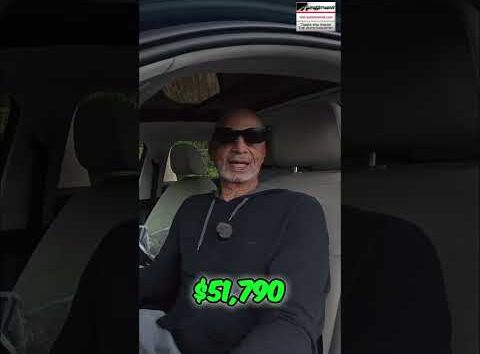 Green dollar bills, symbolizing money, held by a person in a car.