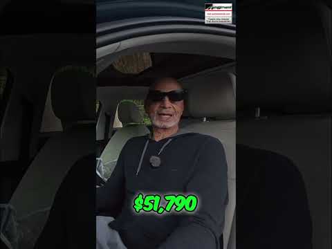 Green dollar bills, symbolizing money, held by a person in a car.