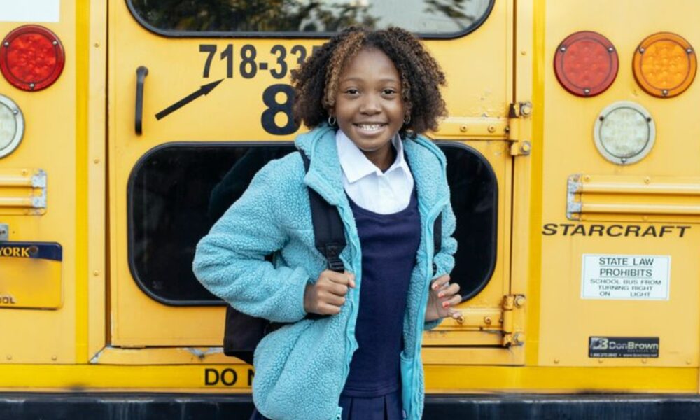 happy ethnic schoolchild near bus on city roadPhoto by Mary Taylor on Pexels.com