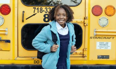 happy ethnic schoolchild near bus on city roadPhoto by Mary Taylor on Pexels.com