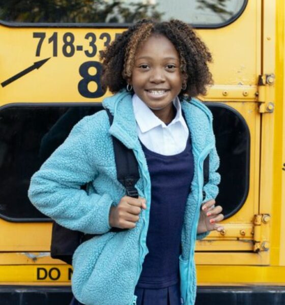 happy ethnic schoolchild near bus on city roadPhoto by Mary Taylor on Pexels.com